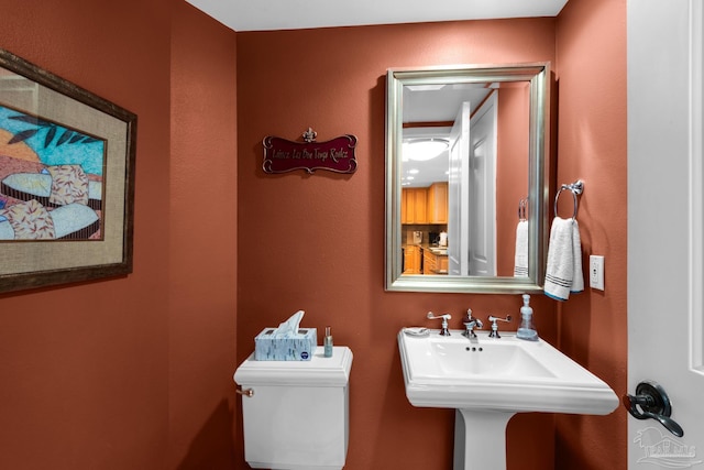 half bathroom featuring toilet and a sink