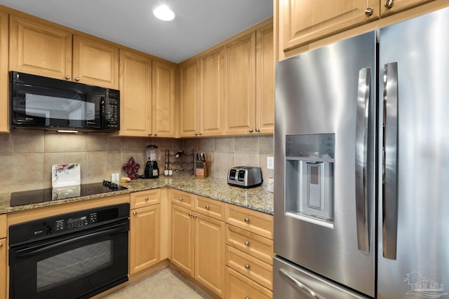 kitchen with tasteful backsplash, light stone counters, and black appliances