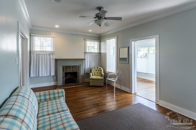 unfurnished living room with a fireplace, ornamental molding, ceiling fan, wood finished floors, and baseboards