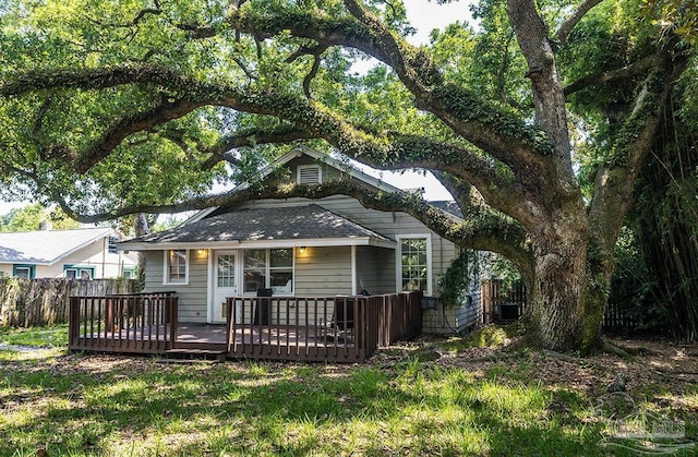 rear view of house featuring fence and a deck