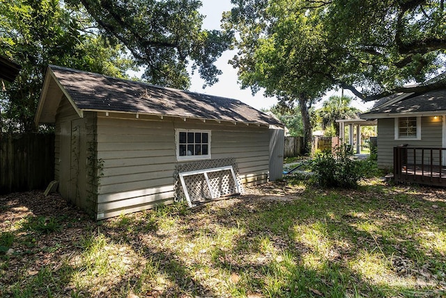 view of outbuilding featuring fence and an outdoor structure