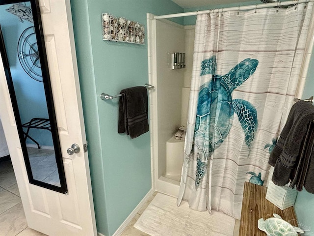 bathroom with curtained shower and baseboards