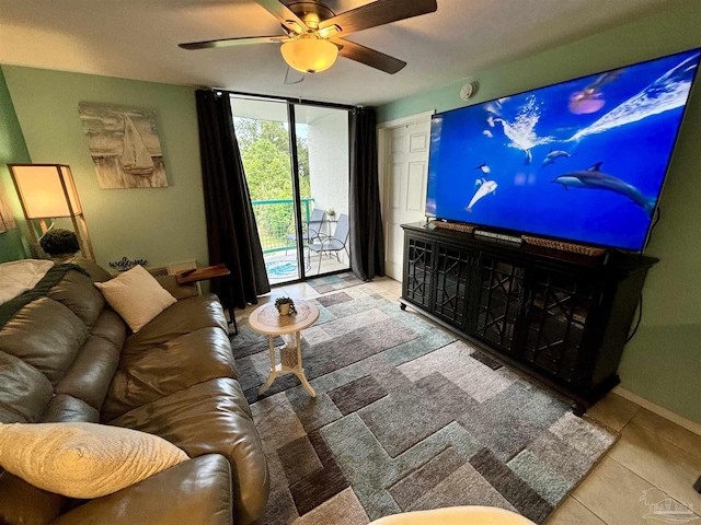 living room featuring tile patterned flooring, a ceiling fan, and baseboards