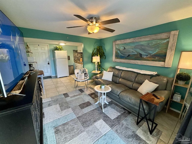 living area featuring baseboards, ceiling fan, and light tile patterned floors