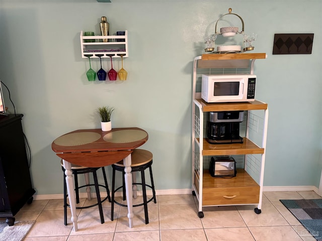 dining space featuring baseboards and light tile patterned floors