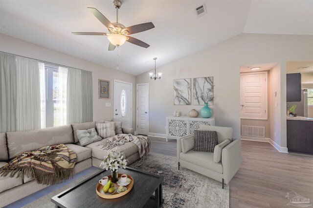 living room featuring light hardwood / wood-style flooring, a healthy amount of sunlight, and lofted ceiling