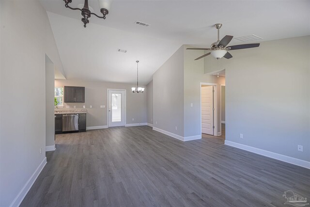 unfurnished living room featuring dark wood-type flooring, ceiling fan with notable chandelier, and vaulted ceiling