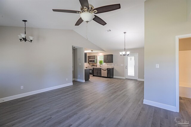 unfurnished living room featuring dark wood-type flooring, high vaulted ceiling, and ceiling fan with notable chandelier