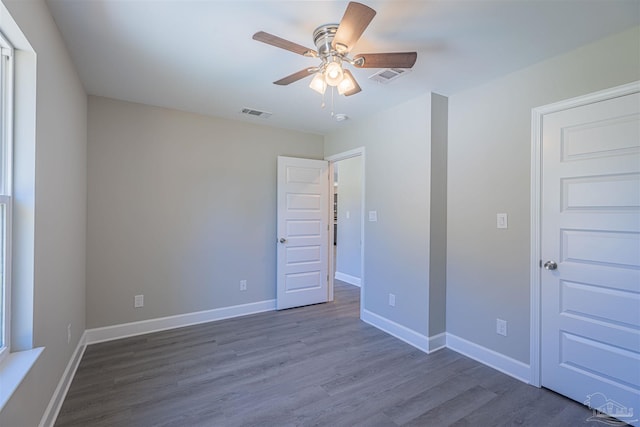 unfurnished bedroom featuring dark wood-type flooring and ceiling fan