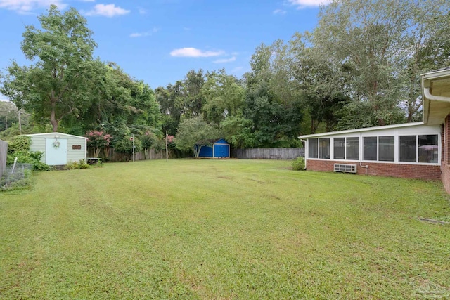 view of yard featuring a sunroom and a storage shed