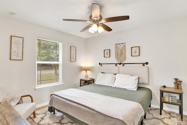 bedroom with a ceiling fan and baseboards