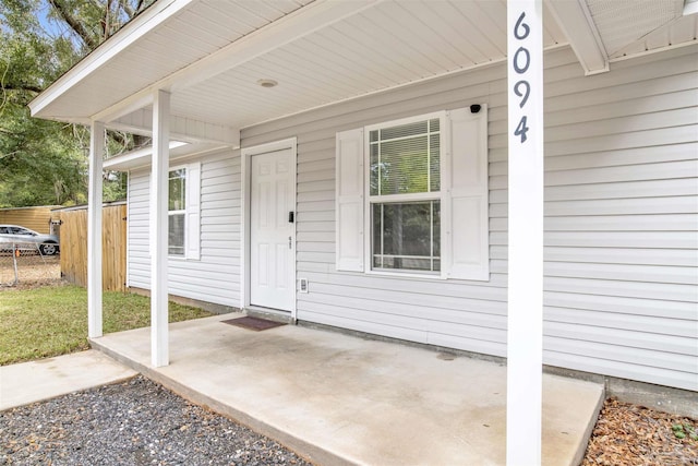 property entrance with a patio area and fence