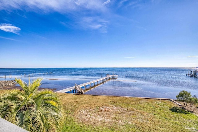 view of dock with a yard and a water view