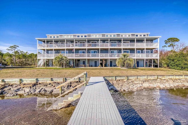 view of dock featuring a yard, a balcony, and a water view