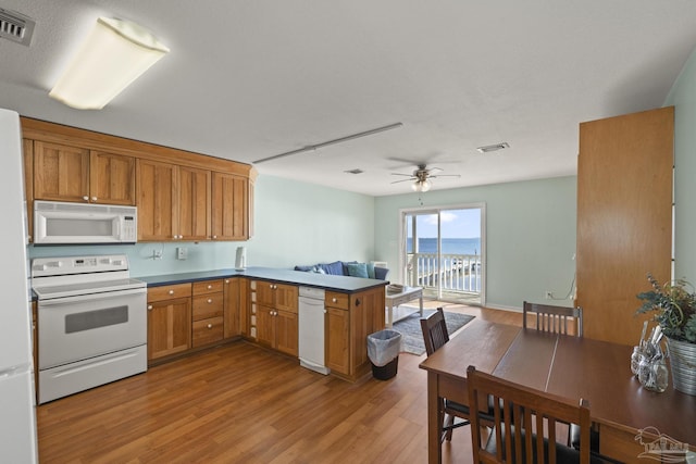 kitchen with white appliances, ceiling fan, light hardwood / wood-style flooring, and kitchen peninsula