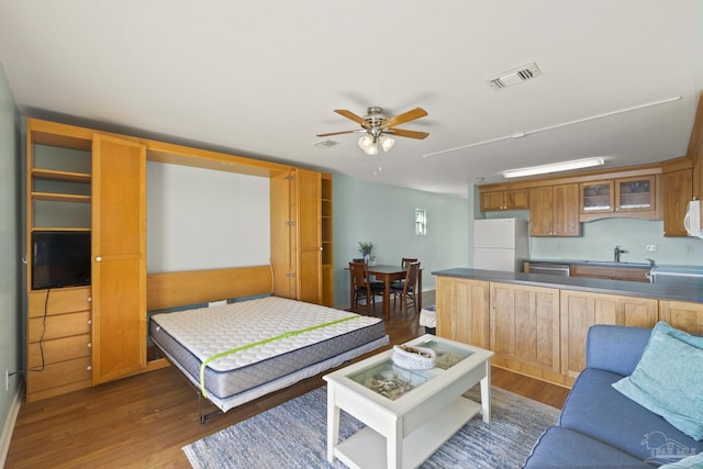 living room featuring ceiling fan, dark hardwood / wood-style floors, and sink