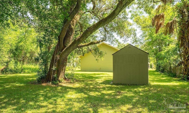 1002 Yonge St, Pensacola, FL 32501 - view of green lawn with a storage shed and an outdoor structure