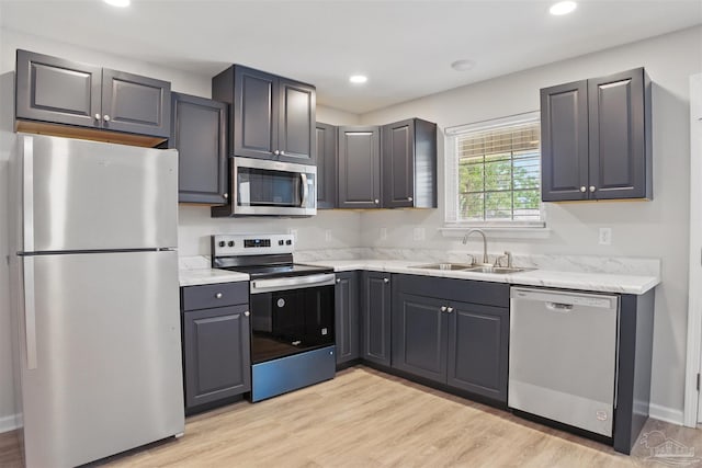 1002 Yonge St, Pensacola, FL 32501 - kitchen with stainless steel appliances, a sink, light wood-type flooring, recessed lighting, and light stone countertops