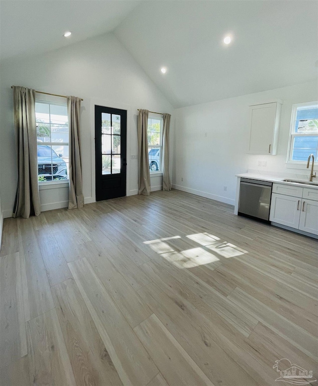 unfurnished living room with sink, high vaulted ceiling, and light wood-type flooring