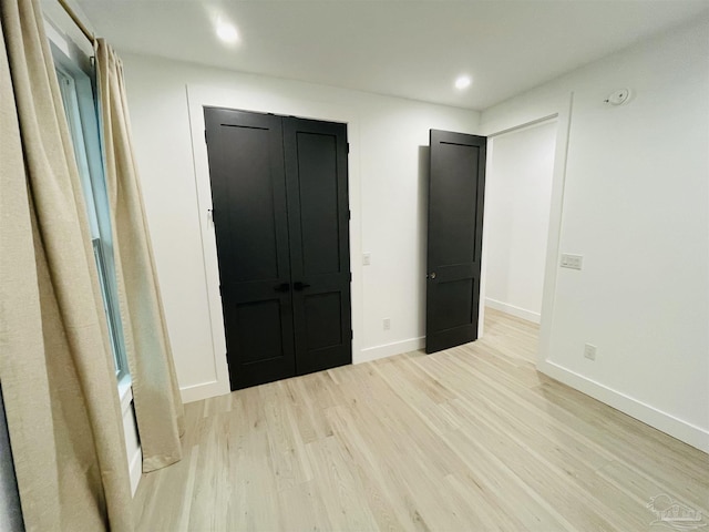 unfurnished bedroom featuring light hardwood / wood-style floors and a closet