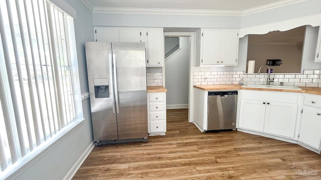 2708 Willow Grove Ln, Ft Walton Beach, FL 32547 - kitchen featuring stainless steel appliances, a sink, butcher block countertops, ornamental molding, and tasteful backsplash