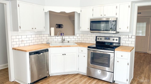 2708 Willow Grove Ln, Ft Walton Beach, FL 32547 - kitchen with appliances with stainless steel finishes, butcher block countertops, a sink, decorative backsplash, and light wood finished floors