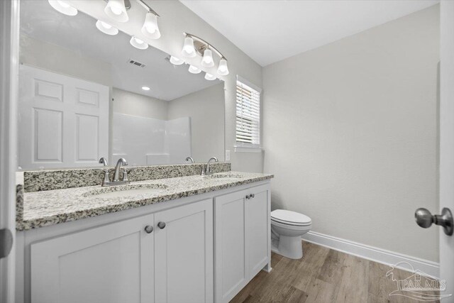 bathroom with toilet, hardwood / wood-style floors, and vanity