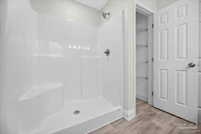 bathroom featuring walk in shower and hardwood / wood-style floors