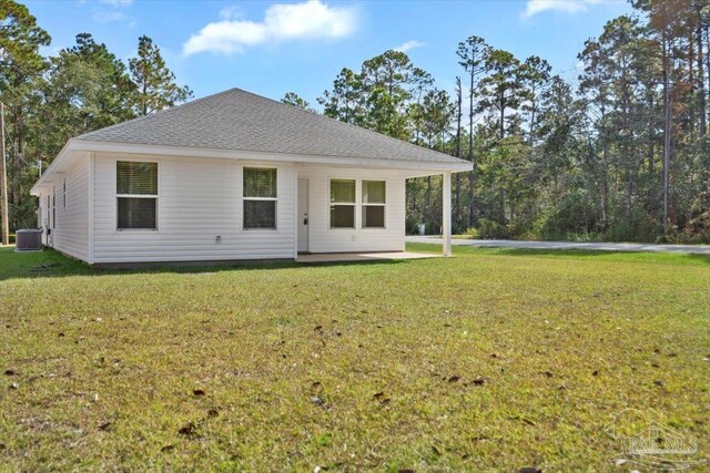 back of property with cooling unit and a lawn