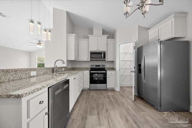 kitchen with lofted ceiling, appliances with stainless steel finishes, white cabinetry, light hardwood / wood-style floors, and sink