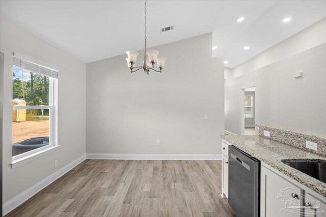 kitchen with dishwasher, light hardwood / wood-style flooring, light stone countertops, vaulted ceiling, and pendant lighting