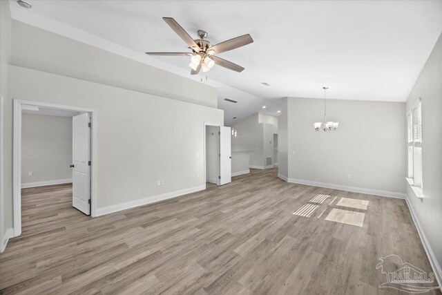 unfurnished living room featuring vaulted ceiling, light hardwood / wood-style flooring, and ceiling fan with notable chandelier