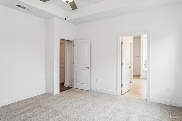 unfurnished bedroom featuring baseboards, visible vents, and light colored carpet