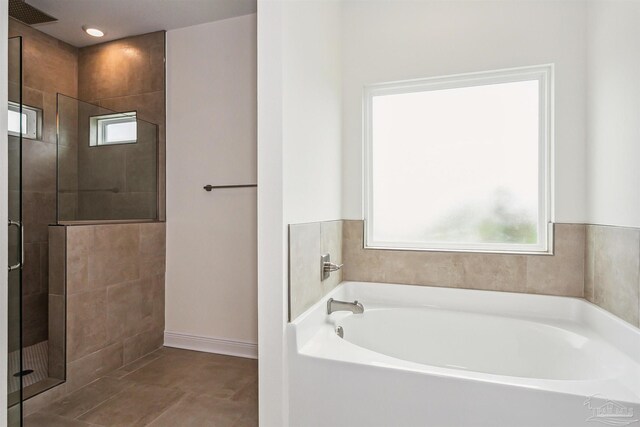 bathroom with baseboards, visible vents, a shower stall, and a bath