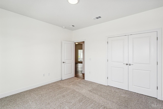 unfurnished bedroom with visible vents, carpet, baseboards, and a closet