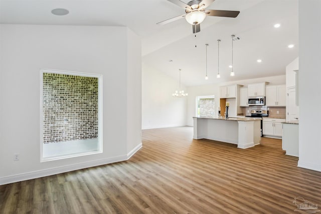 kitchen featuring white cabinets, stainless steel appliances, wood finished floors, and ceiling fan with notable chandelier