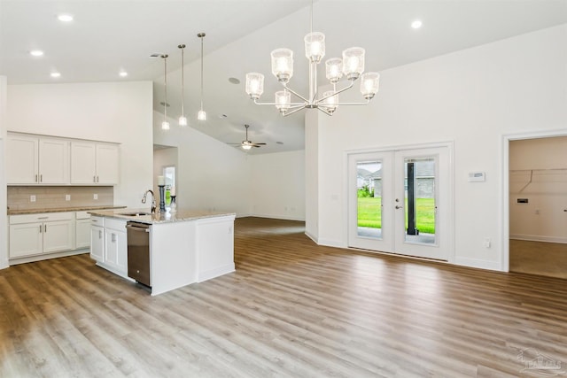 kitchen with white cabinets, a sink, dishwasher, high vaulted ceiling, and open floor plan