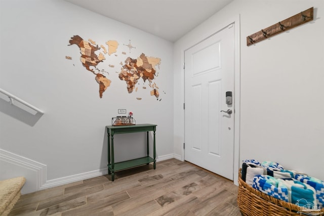 foyer with light wood-style flooring and baseboards