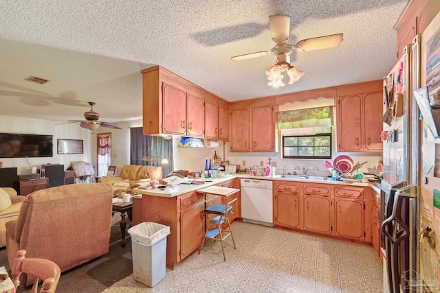 kitchen with kitchen peninsula, ceiling fan, white dishwasher, a textured ceiling, and sink