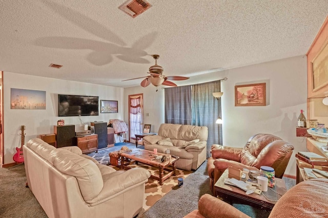 living room featuring carpet, ceiling fan, and a textured ceiling