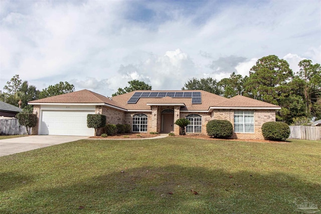 ranch-style home with a front yard, a garage, and solar panels