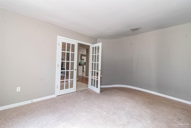 empty room featuring french doors and carpet flooring