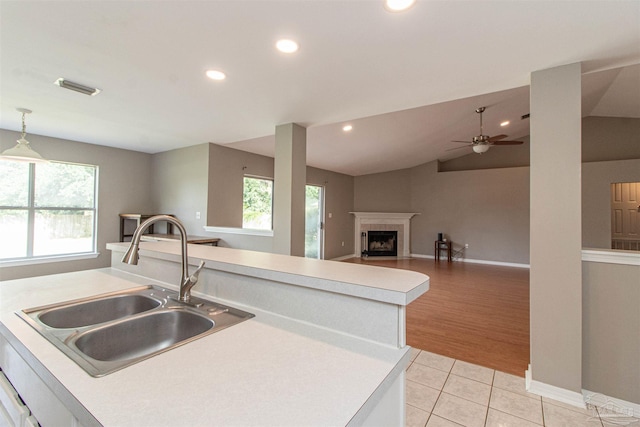 kitchen featuring light hardwood / wood-style flooring, sink, vaulted ceiling, decorative light fixtures, and ceiling fan