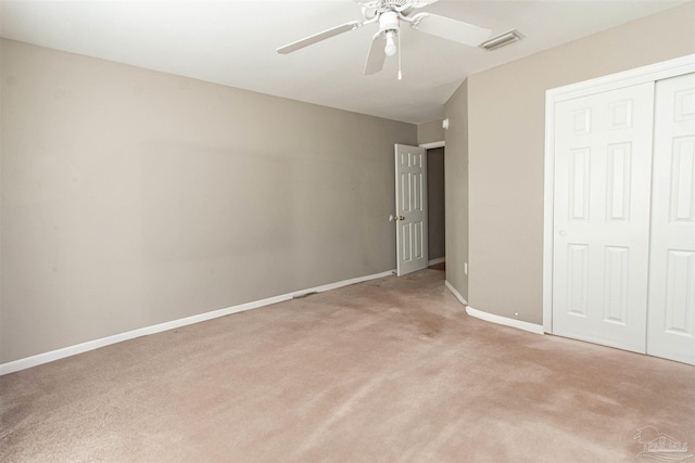 unfurnished bedroom with light colored carpet, a closet, and ceiling fan