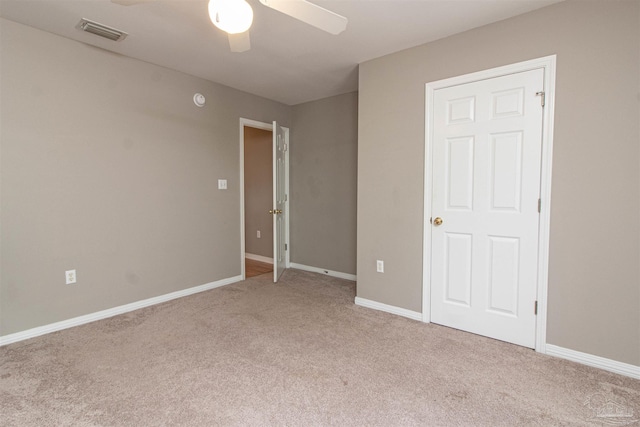 unfurnished bedroom with light colored carpet and ceiling fan