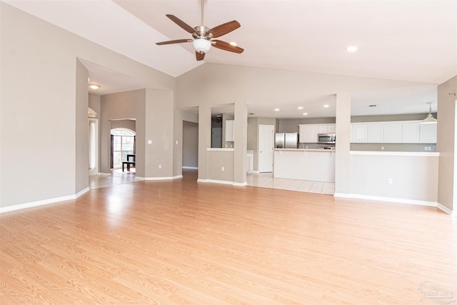 unfurnished living room with ceiling fan, lofted ceiling, and light hardwood / wood-style flooring