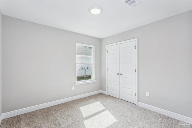 unfurnished bedroom featuring carpet flooring and a closet