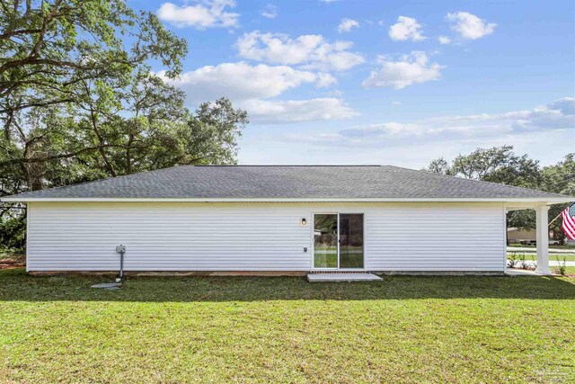 rear view of house featuring a lawn