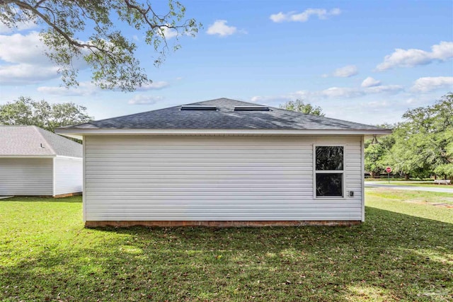 view of property exterior featuring a lawn and an outdoor structure