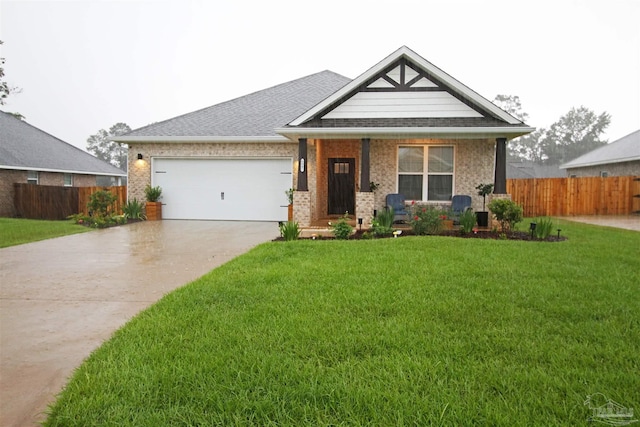 view of front of home featuring an attached garage, brick siding, fence, driveway, and a front lawn